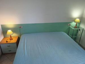 a bedroom with a bed and two lamps on a nightstand at Da Nanni in Villasimius