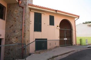 a house with a gate and a building at Da Nanni in Villasimius