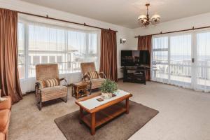 a living room with a couch and a tv at Beach House On Hamblyn in New Plymouth