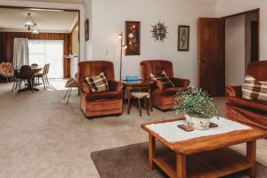 a living room with leather chairs and a table at Beach House On Hamblyn in New Plymouth +20 photos