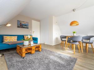 a living room with a blue couch and a table at Haus-Fahnert-1 in Kampen