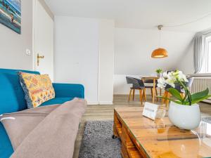 a living room with a blue couch and a table at Haus-Fahnert-1 in Kampen