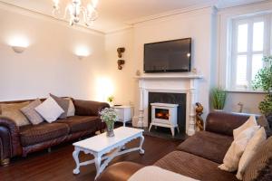 a living room with two couches and a fireplace at Big Pink House in Mealsgate