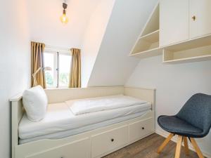 a bed in a room with a chair and a window at Haus-Fahnert-1 in Kampen