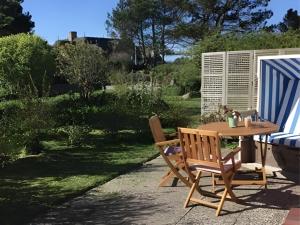 a table and chairs on a patio with a garden at Haus-Fahnert-1 in Kampen +5 photos