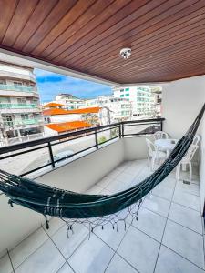 a hammock on a balcony with a view at Hospedatom - Apartamento Economy Prainha Arraial do Cabo in Arraial do Cabo