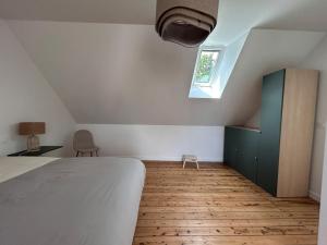 a bedroom with a bed and a green cabinet and a window at Au gré des marées - proche mer in Plérin