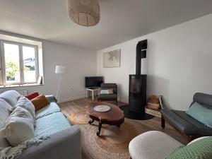 a living room with a couch and a wood stove at Au gré des marées - proche mer in Plérin