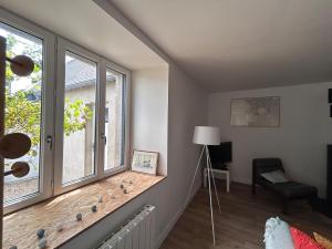 een woonkamer met een raam en een stoel bij Au gré des marées - proche mer in Plérin +13 foto's