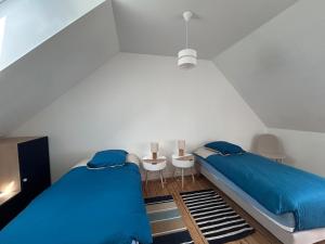 two beds in a small room with blue sheets at Au gré des marées - proche mer in Plérin +13 photos