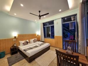 a bedroom with a large bed and a window at Aangan Royal Stay in Dharmsala