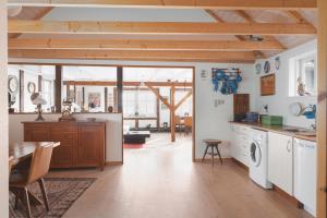 cocina y comedor con mesa y lavadora en Toftarstova - Seaview - Historic - 3BR House, en Kvívík 24 fotos más