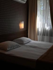 a bed with two pillows in a bedroom with a window at Kryve Ozero in Novoyavorivsk