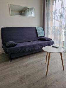 un salon avec un canapé bleu et une table dans l'établissement Bord de mer avec piscine intérieure chauffée, à Port-la-Nouvelle