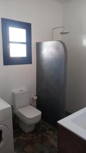 a bathroom with a toilet and a sink and a window at Villa Argos in Agios Georgios
