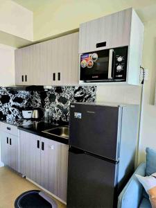 a kitchen with a black refrigerator and a microwave at Casa Istilo Studio at Avida Abreeza Davao in Davao City +8 photos