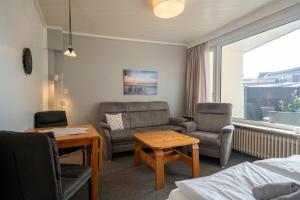 ein Wohnzimmer mit Sofa, Stühlen und einem Tisch in der Unterkunft Haus Sonnenwinkel Bungalow 8 in Dahme