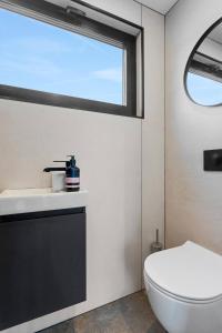 Un baño con inodoro blanco y ventana. en Modern Selfoss Studio, en Selfoss