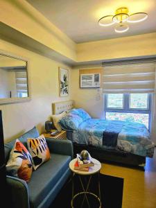 a living room with a couch and a bed at Casa Istilo Studio at Avida Abreeza Davao in Davao City