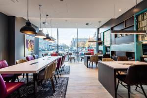 a restaurant with tables and chairs and a view of a city at Premier Inn Essen City Centre in Essen
