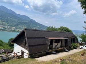 a house with a metal roof on a hill at Trentino Appartamenti Oss in Tenna 