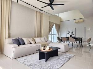 a living room with a white couch and a table at Luxury 4BR Duplex, Medini Apartment in Iskandar Puteri +12 photos
