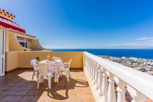 a balcony with a table and chairs and the ocean at Penthouse with ocean views - Torviscas in Adeje