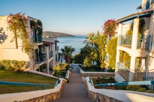 ein Gehweg zwischen zwei Gebäuden neben dem Wasser in der Unterkunft Bodrum Holiday Resort & Spa in Bodrum City