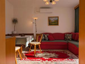 a living room with a red couch and a table at Garden Apartments Janša in Radovljica