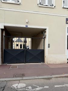 an open garage door with a gate in a building at Au cœur de Vernon - Appartement cosy in Vernon