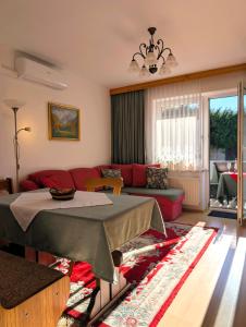 a living room with a red couch and a table at Garden Apartments Janša in Radovljica +66 photos