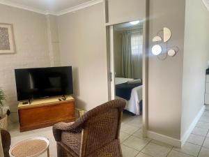 a living room with a television and a chair at 42 On Fraser in Howick +2 photos