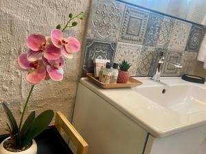 ホウィックにある42 On Fraserのバスルーム(シンク、花のカウンター付) +2枚の写真