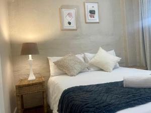 a bedroom with a bed with pillows and a lamp at 42 On Fraser in Howick