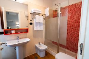 ジュリアーノ・イン・カンパーニアにあるHotel Barbarella Swimmingの洗面台、トイレ、シャワー付きのバスルーム