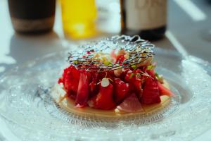 a cake with strawberries on a glass plate on a table at Les Elmes - Hôtel & Spa in Banyuls-sur-Mer +50 photos