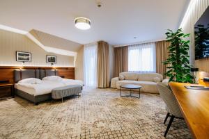 a large hotel room with a bed and a couch at Hotel Cztery Pory Roku in Głogów Małopolski