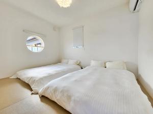 two beds sitting next to each other in a bedroom at 「淡路島一棟貸宿　野うさぎ 」高台から海を望む貸別荘！2023年新築離れの素泊まり in Noda +33 photos