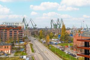 een uitzicht op een stad met een stel kranen bij Modern Apartment with Historic Shipyard Views and Parking by Noclegi Renters in Suchanino