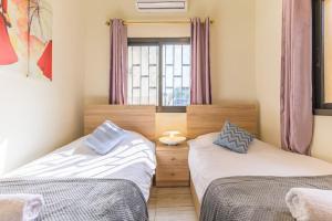 two beds in a room with a window at Daya 2BR Apartment In Batroun in Batroûn
