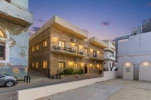 a brick building with a car parked in front of it at Daya 2BR Apartment In Batroun in Batroûn