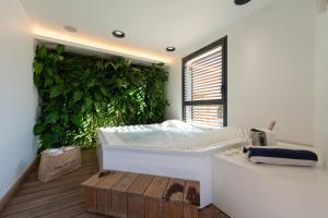 a white bedroom with a large green wall at Les Elmes - Hôtel & Spa in Banyuls-sur-Mer