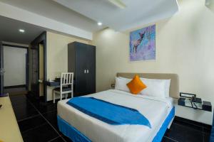a bedroom with a large bed and a desk at Afallon Hotels in Bangalore