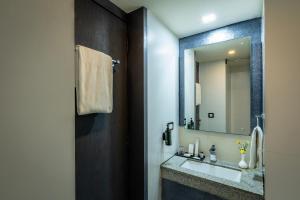 a bathroom with a sink and a mirror at Afallon Hotels in Bangalore +3 photos