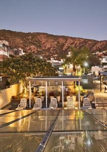 a view of a hotel with chairs and a pool at Hotel Linz in Villa Carlos Paz