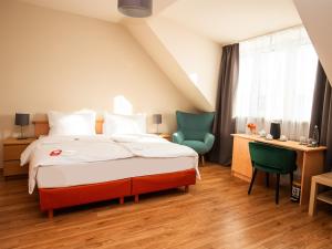 een slaapkamer met een bed en 2 stoelen en een bureau bij Hotel Deutsches Theater Landwehrstraße in München +39 foto's