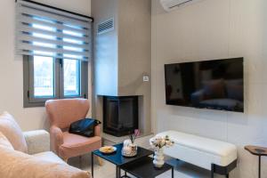 a living room with a couch and chairs and a tv at Lumera Urban Stay - New 2BR Home with Private Parking near Old Town in Chania