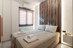 a bedroom with a bed with two towels on it at Lumera Urban Stay - New 2BR Home with Private Parking near Old Town in Chania