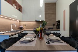a kitchen with a wooden table with wine glasses at Lumera Urban Stay - New 2BR Home with Private Parking near Old Town in Chania