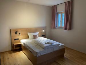 ein Schlafzimmer mit einem Bett und einem Fenster in der Unterkunft Zum Posthalter in Hemau